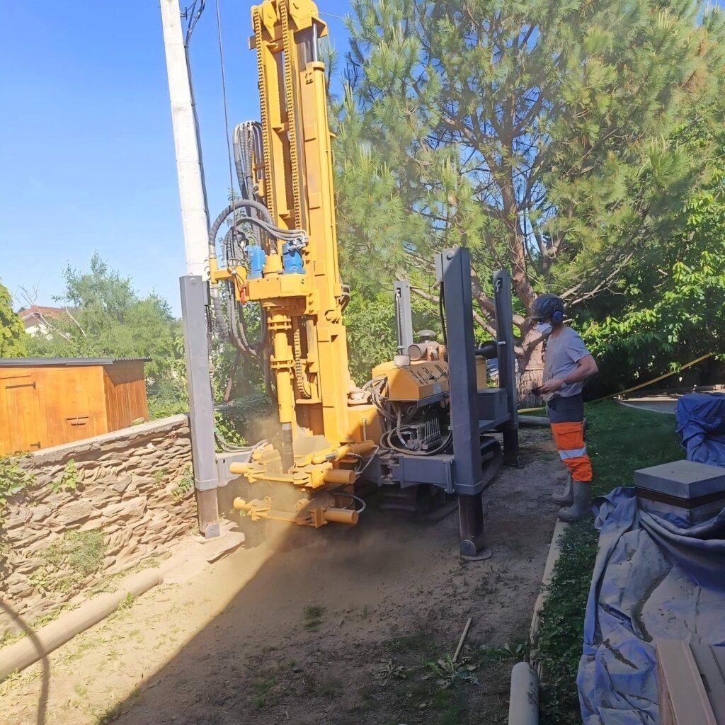 Air drilling water well borehole, drill rig with high‑pressure air compressor blows rock cuttings out of borehole at job site